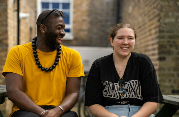 The front cover of Look Ahead's impact report showing a happy young person and support worker laughing together.